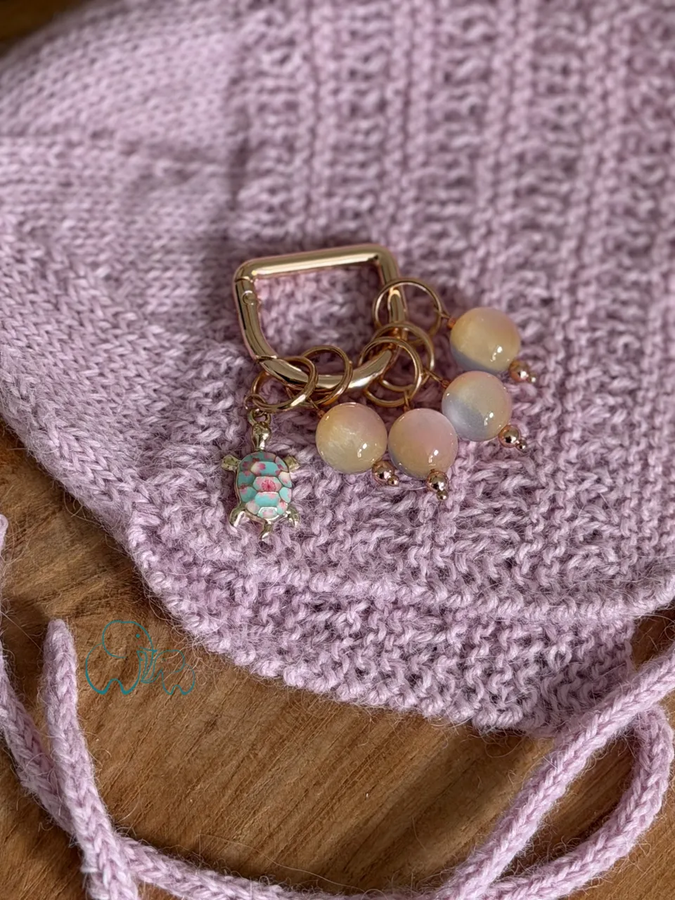 Rosa gestrickte Babymütze mit Maschenmarkierern