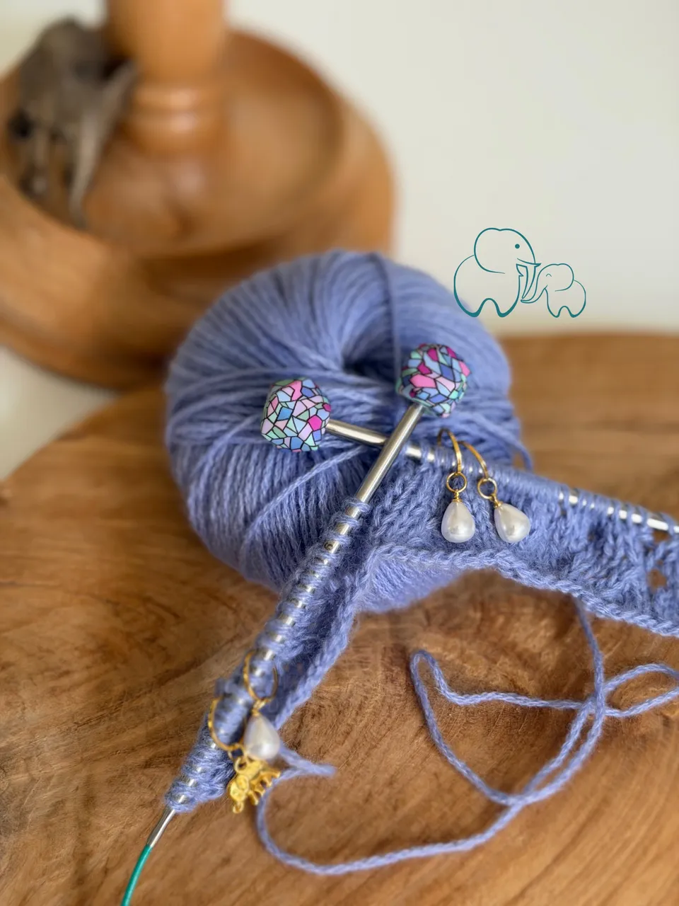Lila Wolle und Strickprojekt mit Maschenmarkierern